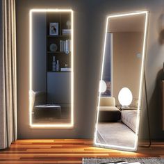 a room with a large mirror and lights on the wall, along with a bed