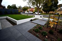 an outdoor garden with steps leading up to the grass and trees in front of it