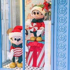 mickey and minnie mouse in front of a store window with candy canes on the windowsill