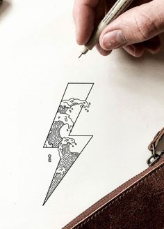 a person is drawing on paper with a pen