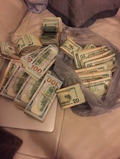 a pile of money sitting on top of a bed