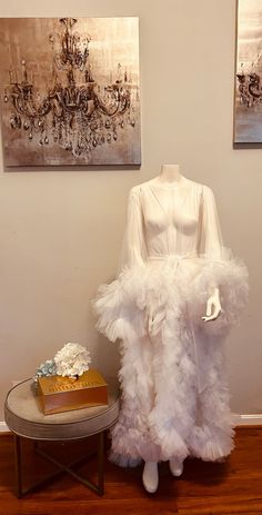 a white dress on display next to a cake