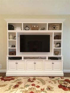 a living room with a large entertainment center and rug on the floor in front of it