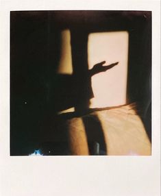 the shadow of a person's hand is cast on a window sill in an old photo