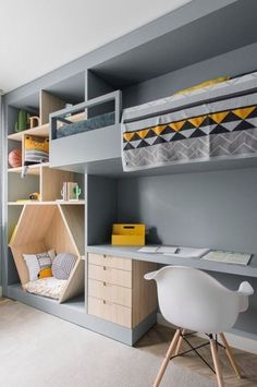 a bedroom with bunk beds, desk and shelves