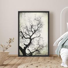 a bedroom with a bed and a poster on the wall above it that has an image of a tree