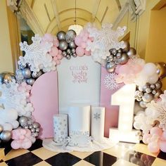 a table topped with lots of white and pink decorations on top of a black and white checkered floor