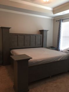 a bedroom with a bed, nightstands and window in it's center area