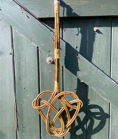 an umbrella made out of wicker hanging from a hook on a wooden door handle