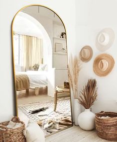 a mirror sitting on top of a wooden table next to a basket filled with plants