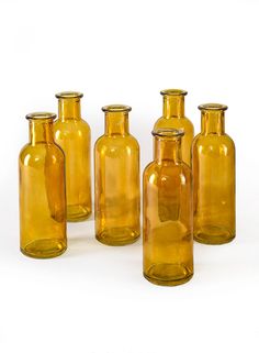 six yellow glass bottles sitting next to each other