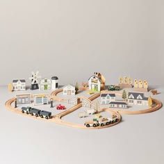 a toy train set with houses and cars