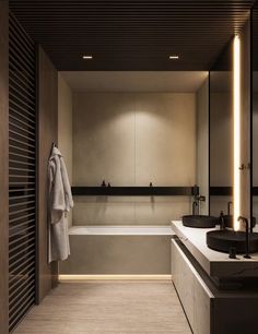 a large bathroom with two sinks and a bathtub in the middle, along with a towel hanging on the wall