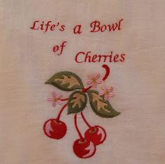 a towel with embroidered cherries on it that says, life's a bowl of cherries