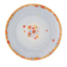 a white plate with orange and yellow sprinkles on the rim against a white background