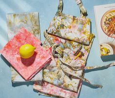 three bags and a lemon on top of a blue table with an open cookbook