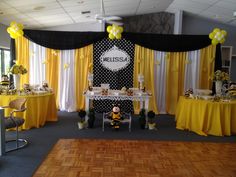 a room with yellow and black decorations on the walls, table cloths and chairs