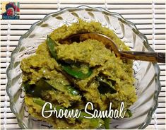 a glass bowl filled with green sauce on top of a table