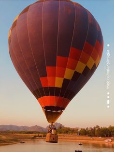 a large hot air balloon flying over a lake