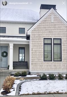 a house with snow on the ground in front of it and a wreath hanging outside