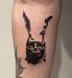 a black and white rabbit tattoo on the leg