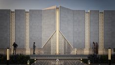 people are standing in front of a tall building with intricate designs on it's sides