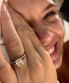 a close up of a person with a ring on their finger and smiling at the camera