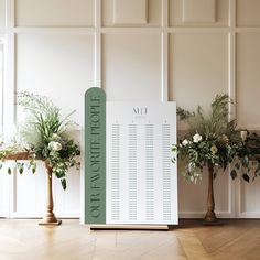 a table plan sitting on top of a wooden floor next to two vases filled with flowers