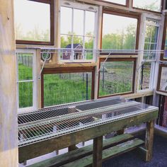 a room filled with lots of windows next to a green field