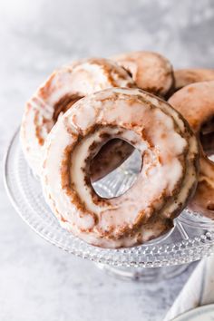 several glazed donuts on a glass plate