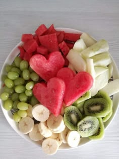 a white plate topped with lots of different types of fruits and veggies next to each other