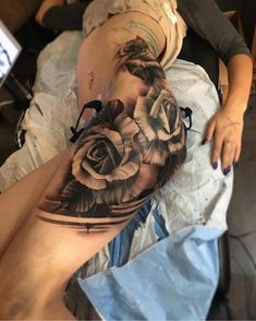 a woman's thigh with roses on it and the bottom half of her leg