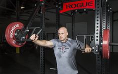 a man is doing squats with a barbell in a crossfit gym