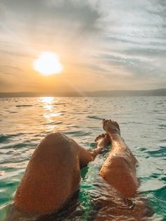 two people are swimming in the ocean with their feet on each other's back