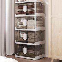 an organized closet with clear bins filled with folded clothes