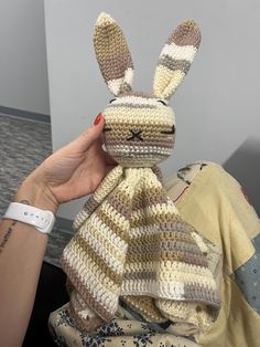 a crocheted stuffed animal is being held up by someone's hand,