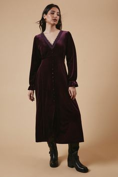 Luxurious velvet fabric for a soft, tactile feel Elegant V-neckline adorned with delicate lace trim Button-through front for a classic, feminine touch Midi length offering versatile styling options Long sleeves with subtle gathering for added interest Embrace effortless elegance with this enchanting velvet midi dress from Oasis. The sumptuous fabric drapes beautifully, creating a flattering silhouette that's perfect for a range of casual occasions. The lace-trimmed V-neckline adds a touch of romance, while the button-through front allows for customisable coverage. Style this versatile piece with ankle boots and a leather jacket for a chic daytime look, or dress it up with heeled sandals and statement earrings for an evening out. The midi length makes it ideal for family gatherings or bru Lace Undershirt, Dresses Velvet, Oasis Dress, Velvet Midi Dress, Oasis Fashion, Loungewear Jumpsuit, Velvet Lace, Draped Fabric, Lace Midi Dress