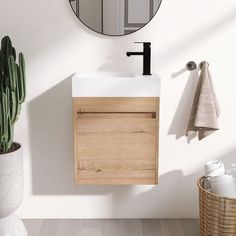 a bathroom with a sink and mirror next to a cactus in a basket on the floor