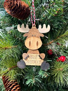 a wooden moose ornament hanging from a christmas tree