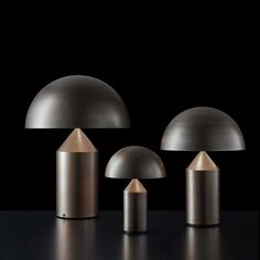 three lamps are shown on a black surface