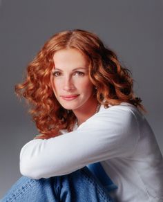 a woman with red hair is posing for the camera