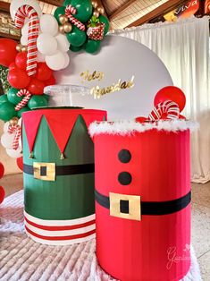 christmas decorations are displayed in front of a wall with balloons and candy canes on it