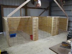 some wooden pallets in a building with metal bars on the sides and plastic containers behind them