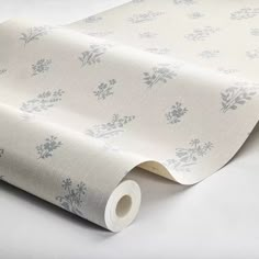 a roll of white wallpaper with blue floral designs on it's edges and bottom