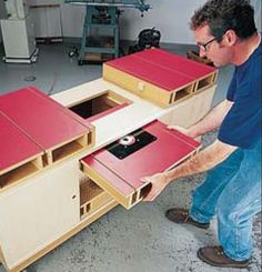 a man is working on some kind of furniture in a garage with red and white drawers