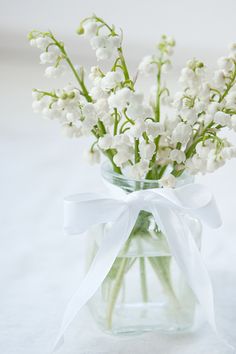 a vase filled with white flowers on top of a table next to a card that says congratulations