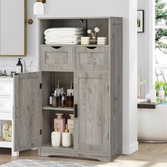 a bathroom cabinet with towels and soaps in it