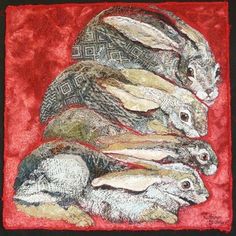 three rabbits sitting on top of each other in the middle of a red cloth background