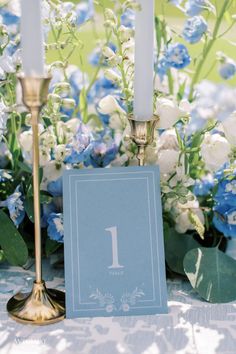 a table topped with blue flowers and candles