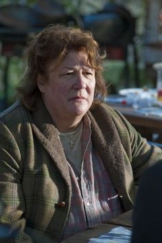 a woman sitting at a table with her eyes closed